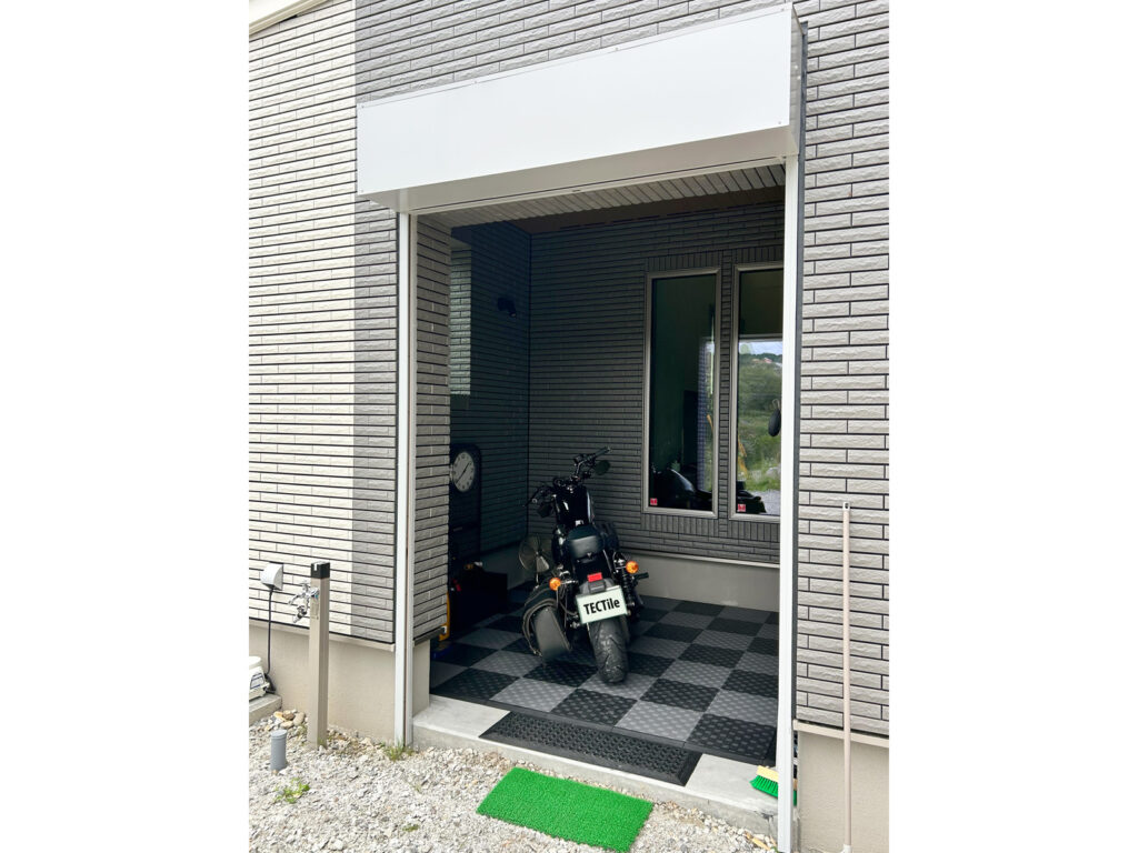 外壁を残した日中のビルトインガレージとバイク